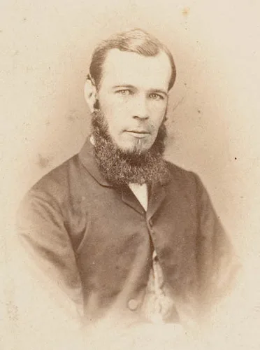 Portrait of David Scott Mitchell, a bearded young man in a dark coat