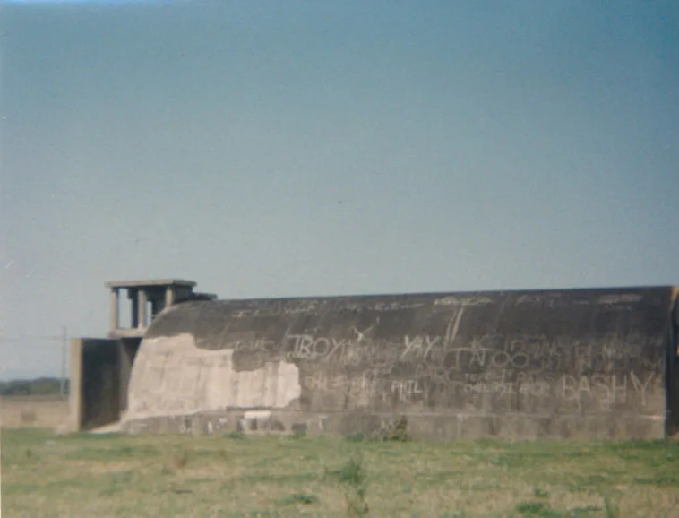 The long concrete igloo covered in graffiti, with the radar tower structure behind