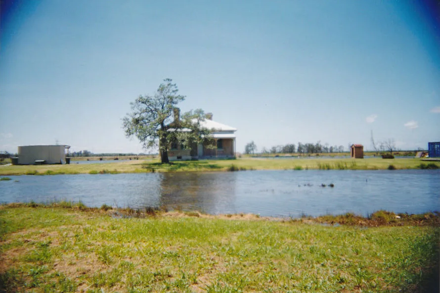 A wider view of the flooded paddocks surrounding the house and its lone tree